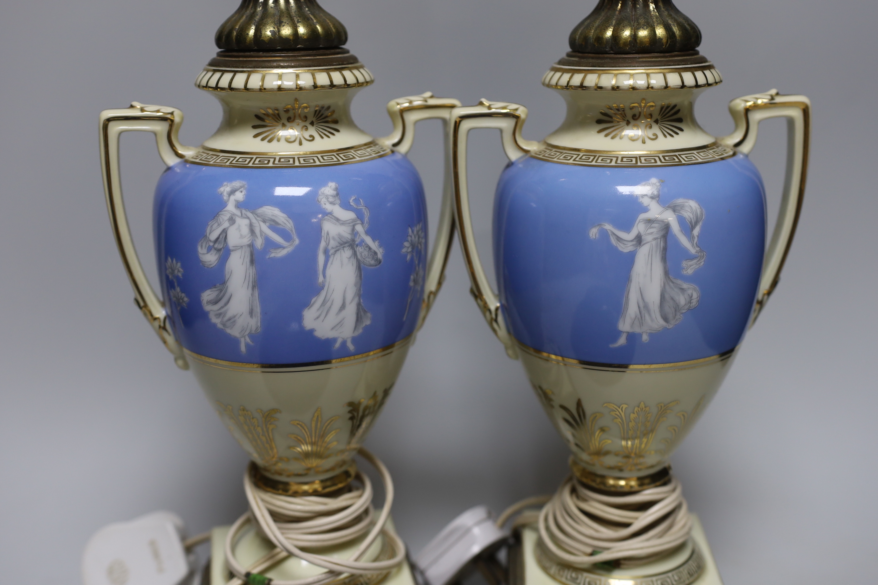 A pair of urn shaped lamps decorated with classical ladies and Greek key borders, together with a pottery bowl, largest 61cm high overall